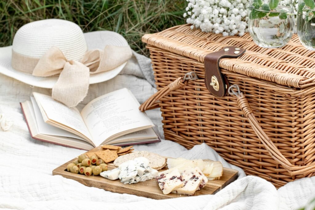 Wicker picnic basket with white linens and a book.