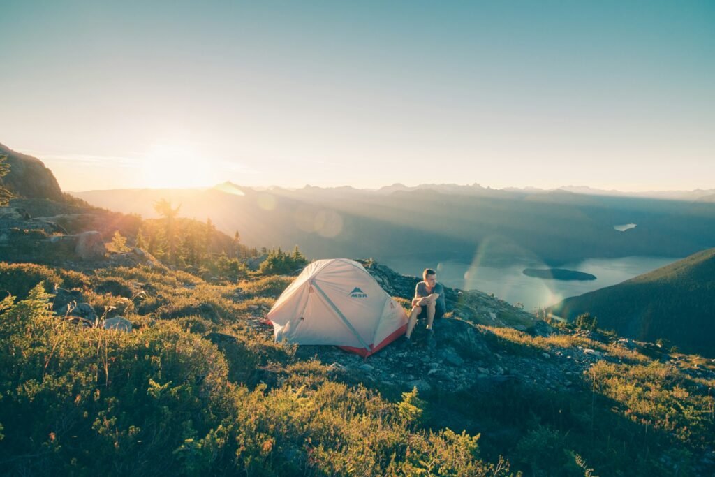 Small tent pitched on a mountain ridge at sunrise.