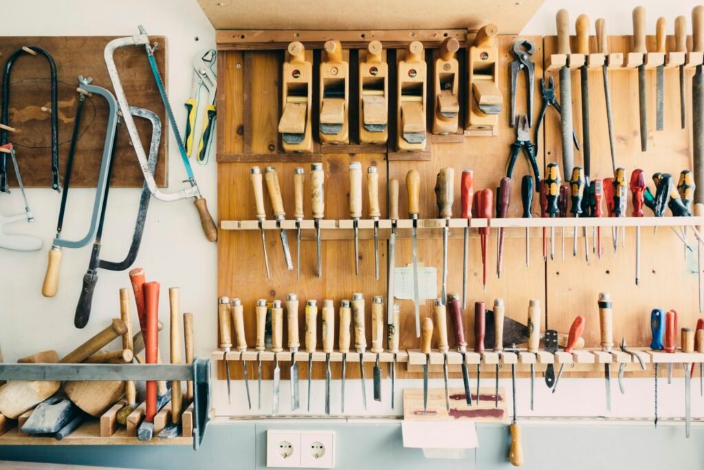 Hand tools neatly hung on a wooden tool wall.