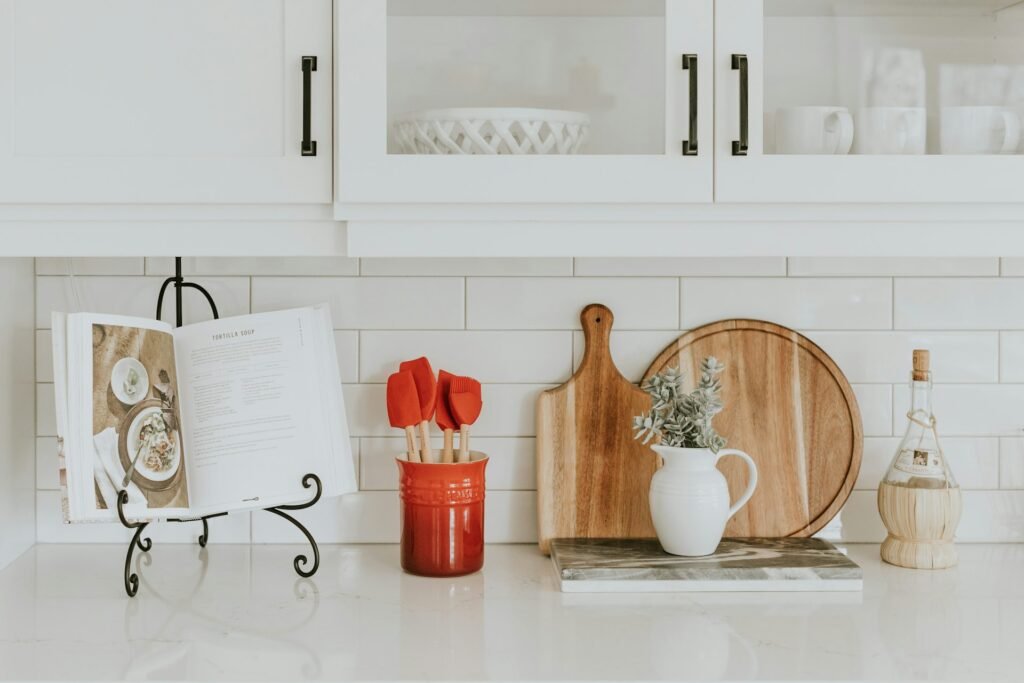White kitchen counter with wooden cutting boards and a recipe book.