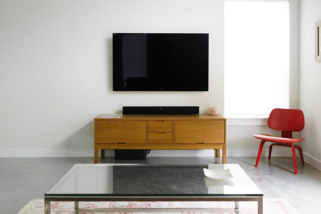 Minimal living room with a wall-mounted TV over a wooden console.