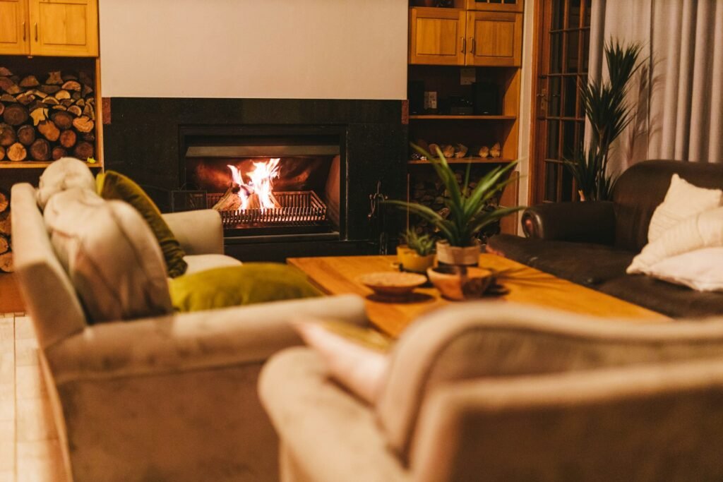Cozy living room with a lit fireplace and warm furniture.