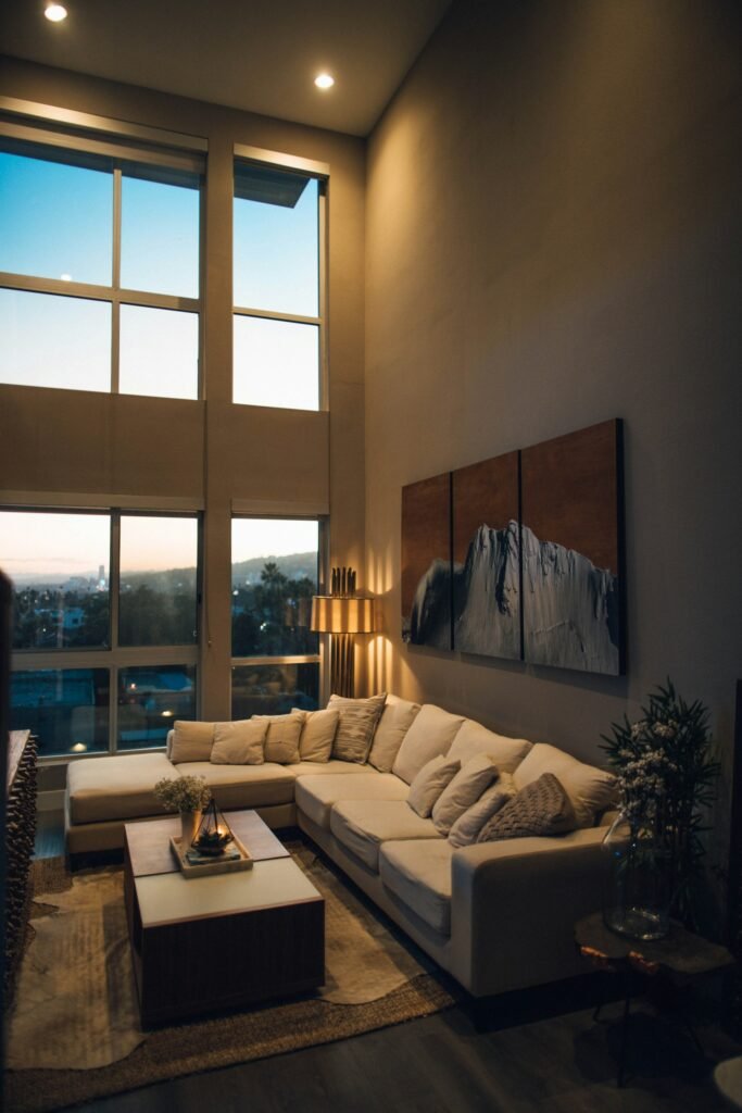 Sectional sofa in a living room with tall windows at sunset