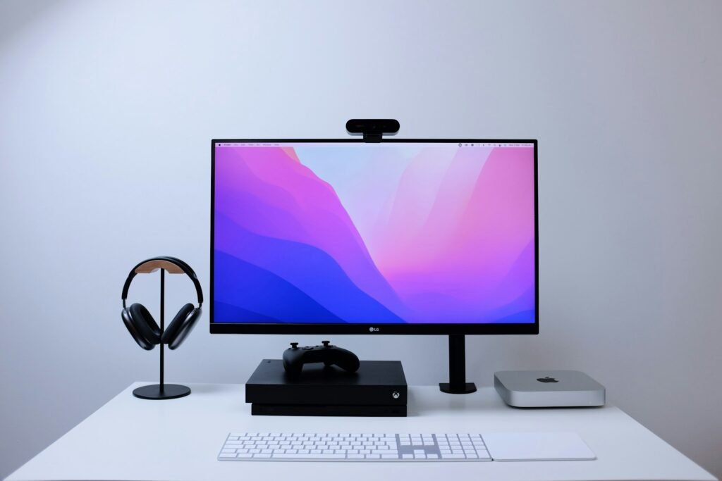 Monitor and headphones on a clean white desk.