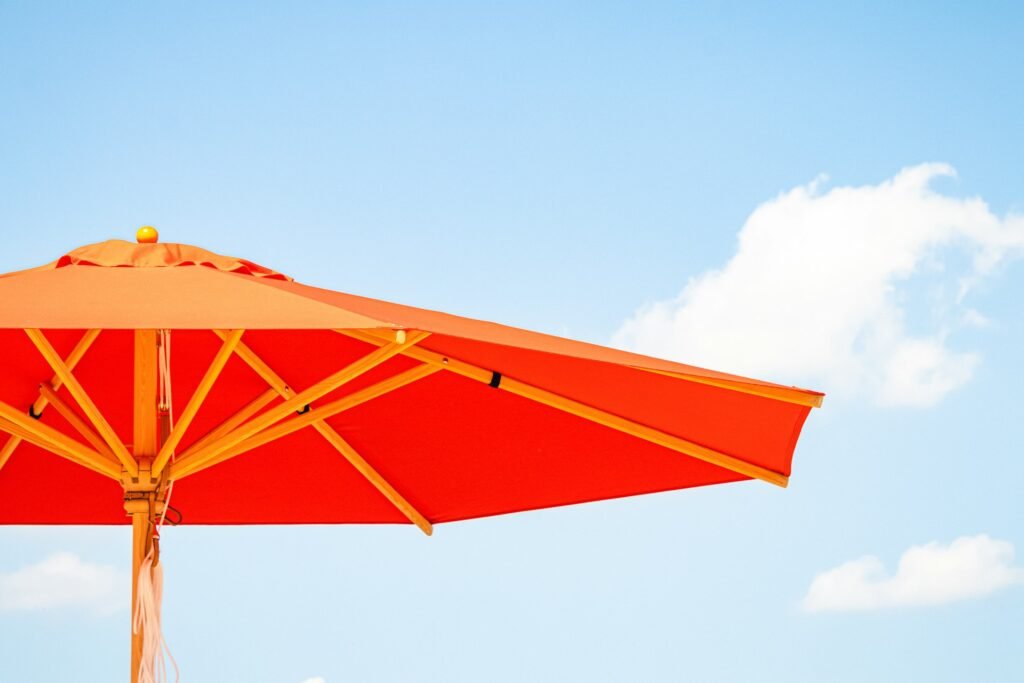 Orange patio umbrella against a blue sky.