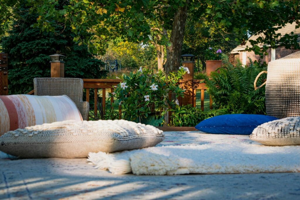 Outdoor patio seating with cushions and lush greenery.