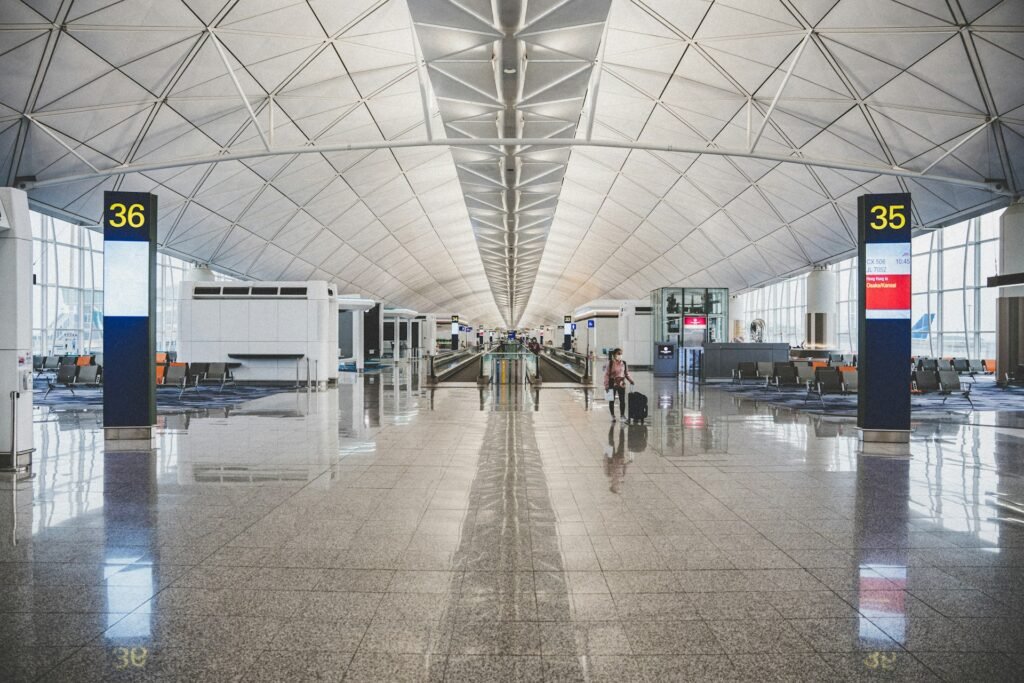 Bright airport concourse with high ceilings and travelers.