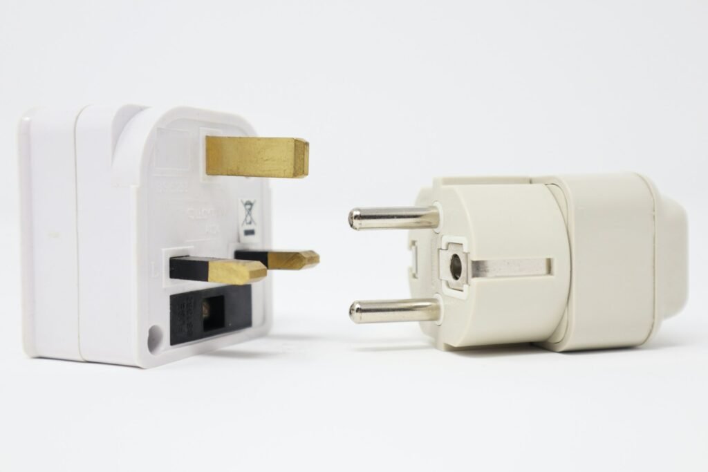 Two white travel plug adapters on a white background.
