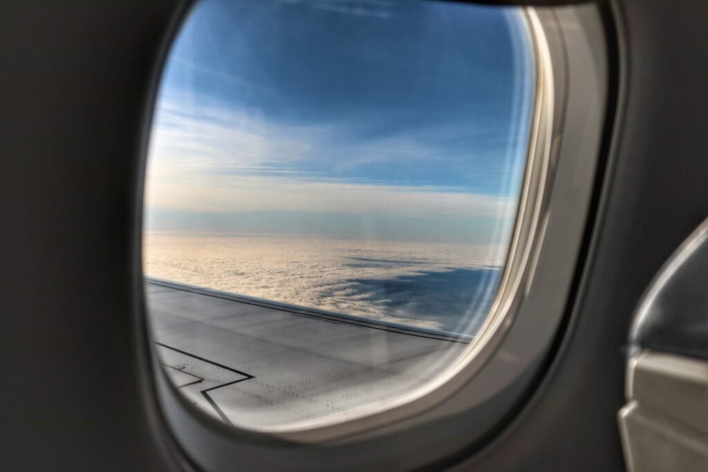 Airplane window view of clouds at sunset.