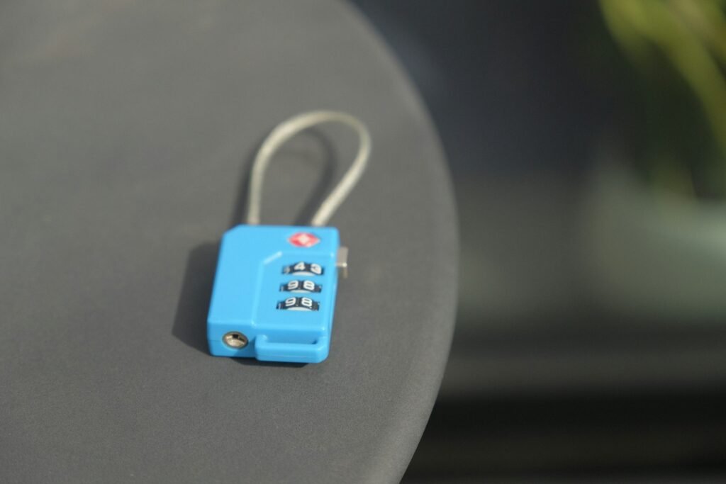 Small blue combination padlock on a luggage surface.