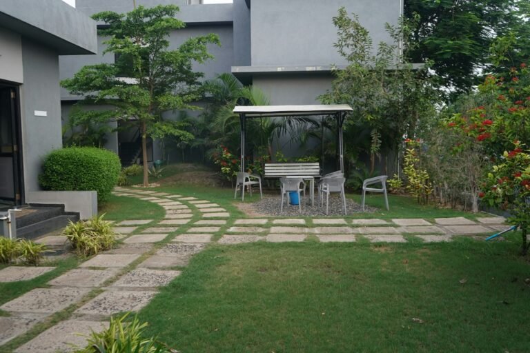 Green backyard with a stone stepping path and a small pavilion